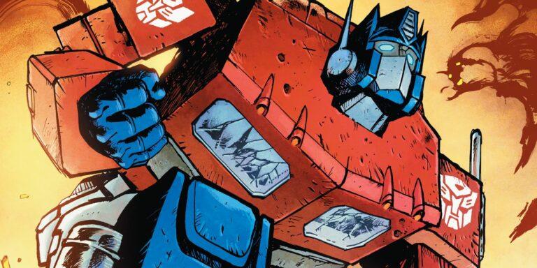 Optimus Prime kneels down in front of fire on cover art for the Energon Universe's Transformers series.